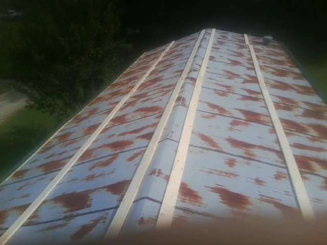 Rusted metal roof panels with new wood purlins before replacement — Storm Damage Roof Repair in Steilacoom by Roofing Brothers